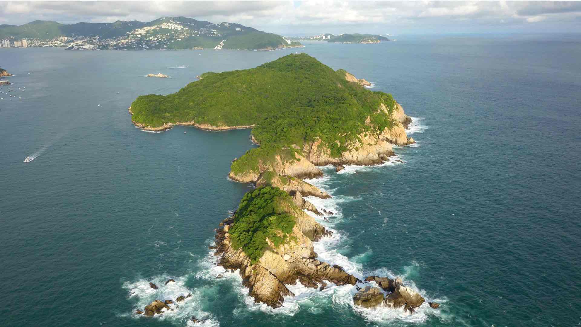 Vista desde el cielo de las playas de la Isla La Roqueta, al fondo el Islote de la Hierbabuena donde reside la Virgen Monumental Reina de los Mares