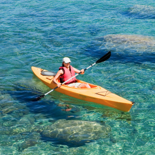 Mujer que navega en kayak en las playas de Isla La Roqueta
